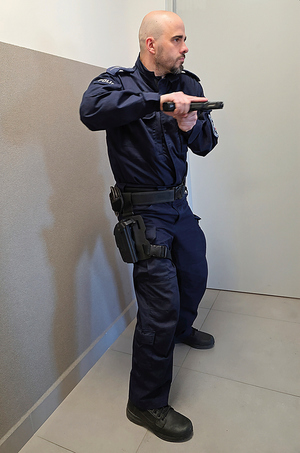 policjant ćwiczy z bronią służbową