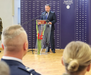 minister MSWiA przemawia na tle niebieskiej planszy