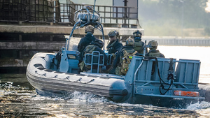 łódź na wodzie wiezie grupę policjantów specjalnej jednostki