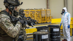 policjanci z bronią, laborant i beczki z czymś niebezpiecznym