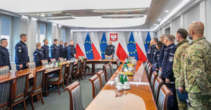 w sali konferencyjnej stoją policjanci i na środku komendant