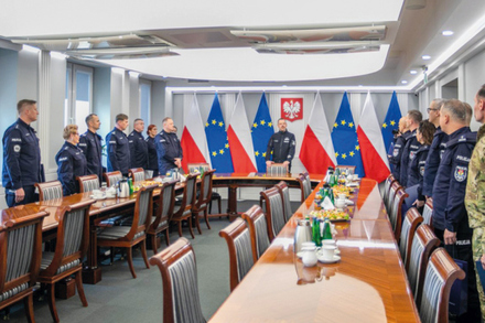 w sali konferencyjnej stoją policjanci i na środku komendant
