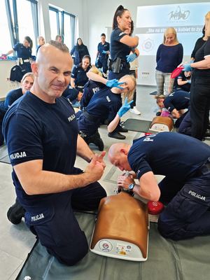 policjantki i policjant ćwiczą resuscytację na manekinie