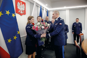 bohaterka materiału na zdjęciach otzrymuje kwiaty od komendanta Kustera