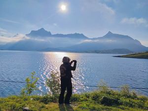 relacja z wycieczki motocyklowej osoba stoi na tle gór robi zdjęcie