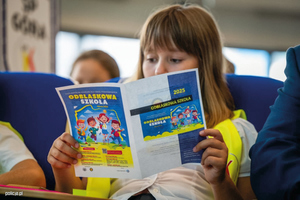 dziewczynka czyta ulotkę