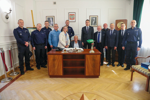 grupa ludzi w pomieszczeniu przy biurku