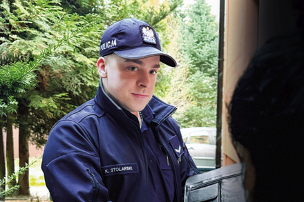 policjant z materiału stoi przy radiowozie