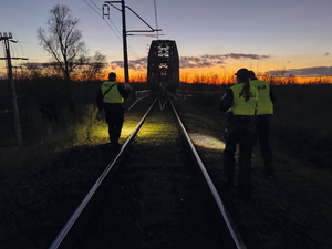 policjanci na moście kolejowym patrolują nocą linie kolejowe i tory