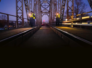 policjanci na moście kolejowym patrolują nocą linie kolejowe i tory