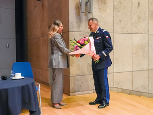 komendant KWP w Krakowie wręcza kobiecie kwiaty