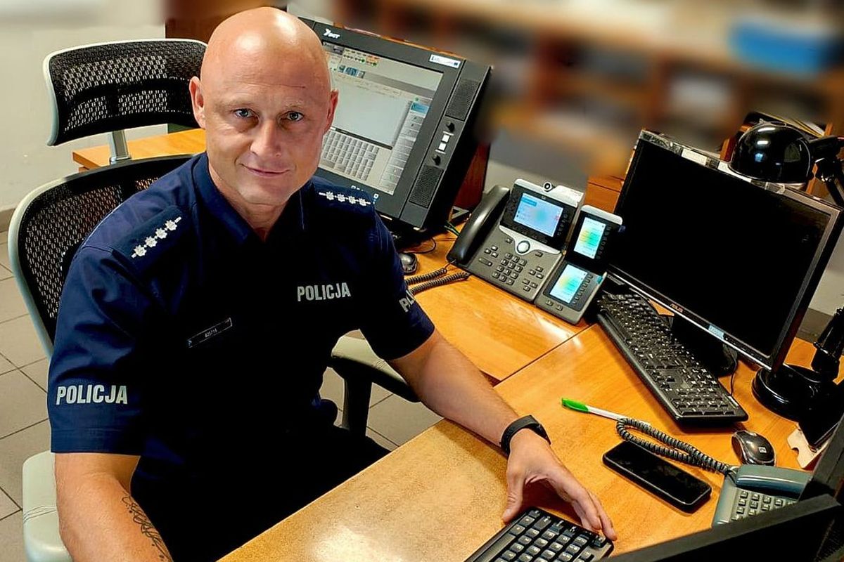 policjant za biurkiem patrzy w obiektyw