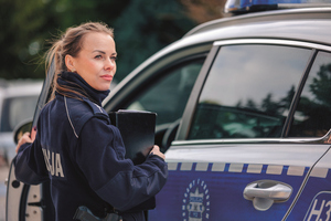 policjantka przy samochodzie policyjnym wsiada do niego