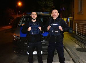 policjanci z materiału o policjantach ratujących obywateli podczas swoich służb przy budynkach i rqadiowozach