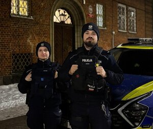 policjanci z materiału o policjantach ratujących obywateli podczas swoich służb przy budynkach i rqadiowozach