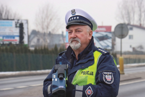 policjant z radarem stoi na drodze