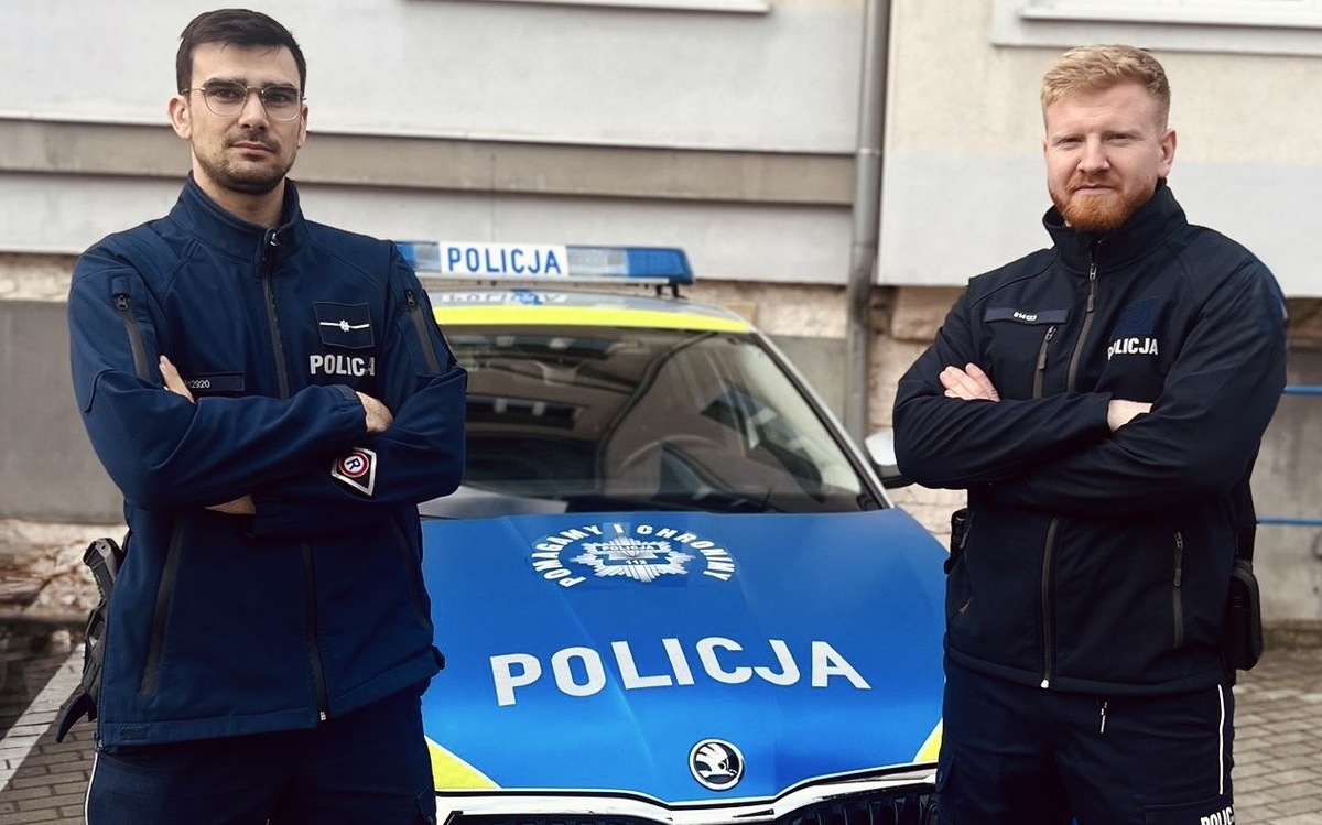 dwa policjanci przy radiowozie